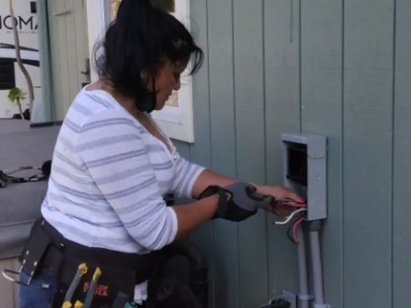 Licensed electrician wiring an exterior subpanel in Tea